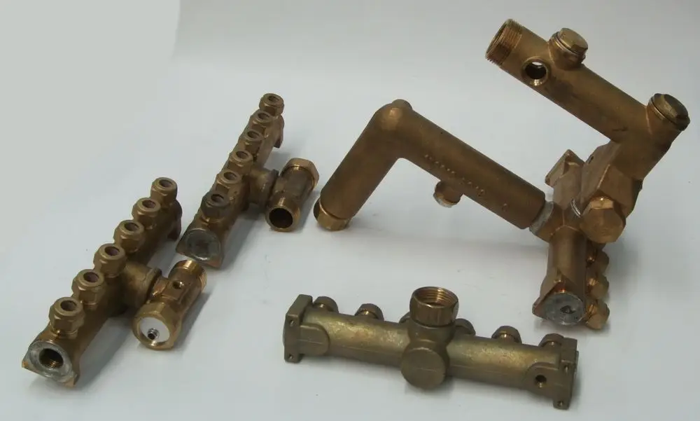 Verteiler-Set aus Messing, bestehend aus mehreren Rohren und Anschlüssen, gedacht für Heizsysteme, möglicherweise von Daikin, angeordnet auf hellem Untergrund.